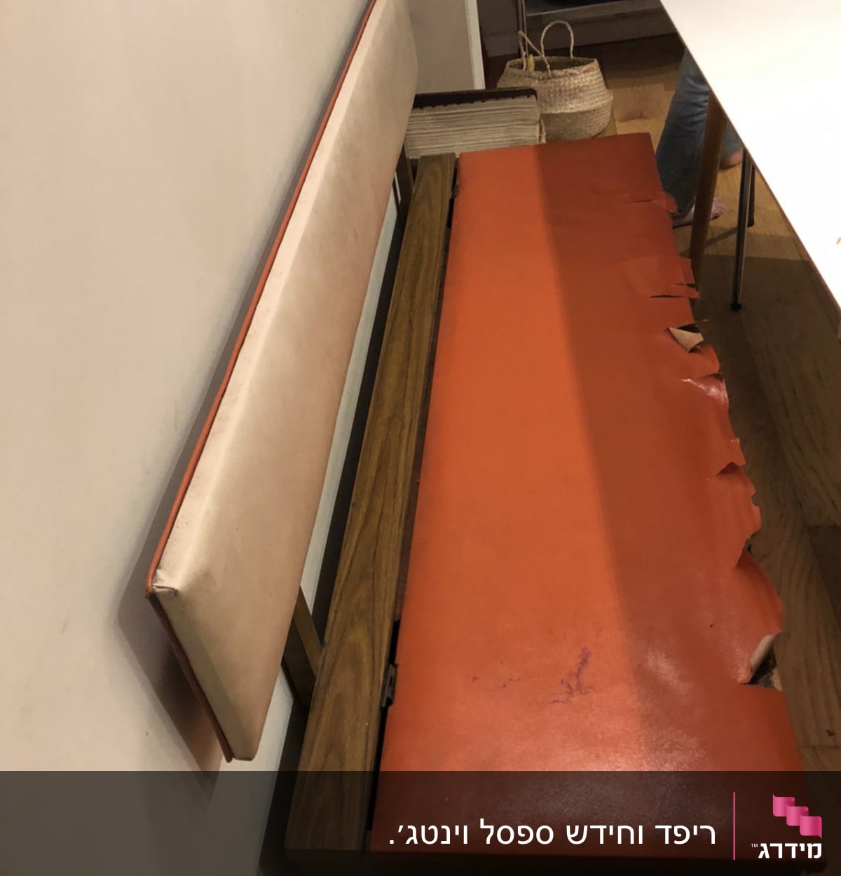 ריפוד כתום קרוע על ספסל עץ
